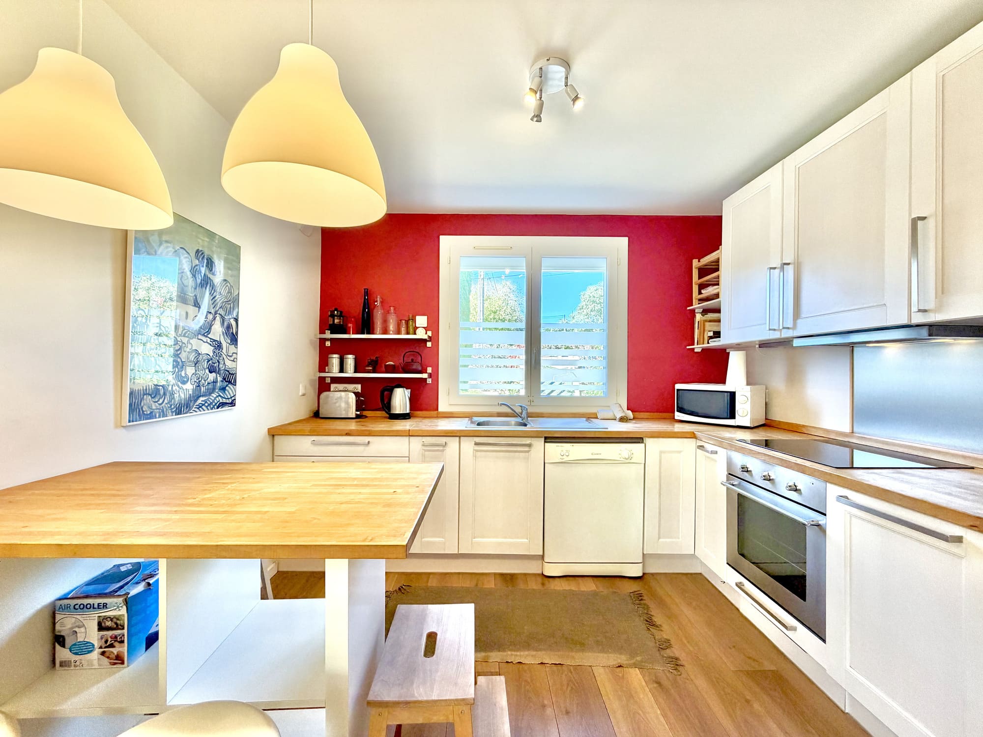 Cuisine avec table haute et mur rouge